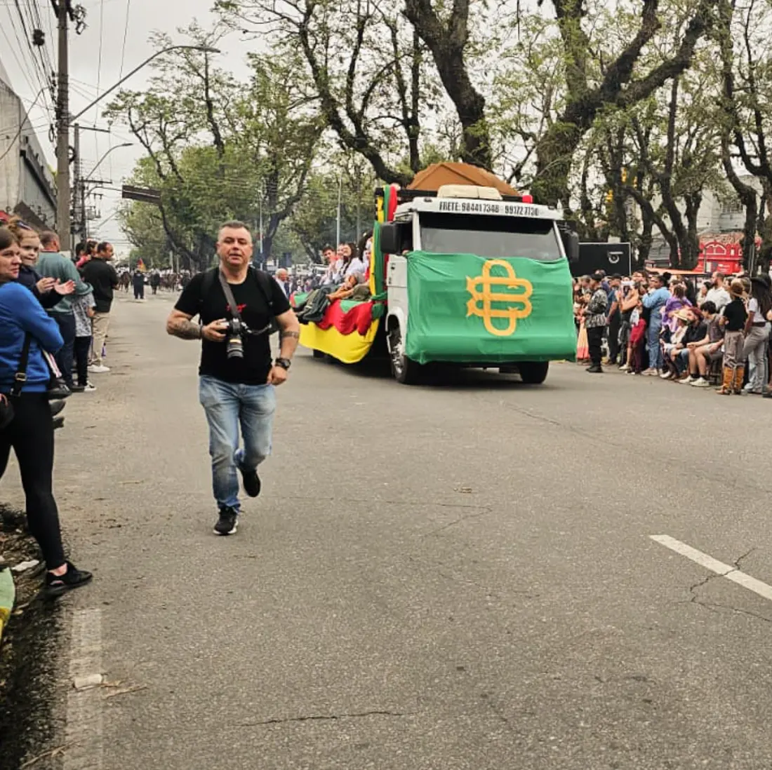 Marco correndo para garantir a foto num desfile